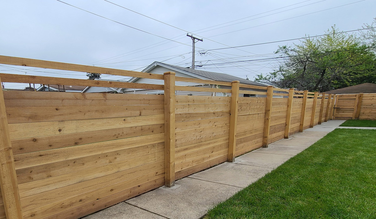 Pressure-treated horizontal wood fence in the bak yard.