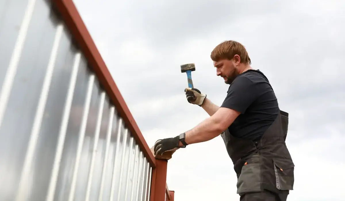 Chicago homeowner struggling with a DIY fence installation on a metal frame, highlighting risks of doing fencing without professional help.
