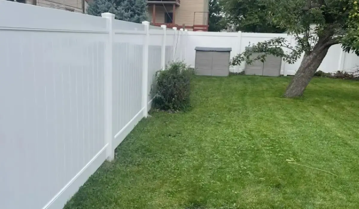 White vinyl privacy fence installed in a suburban Chicago backyard following local HOA fence rules exactly.